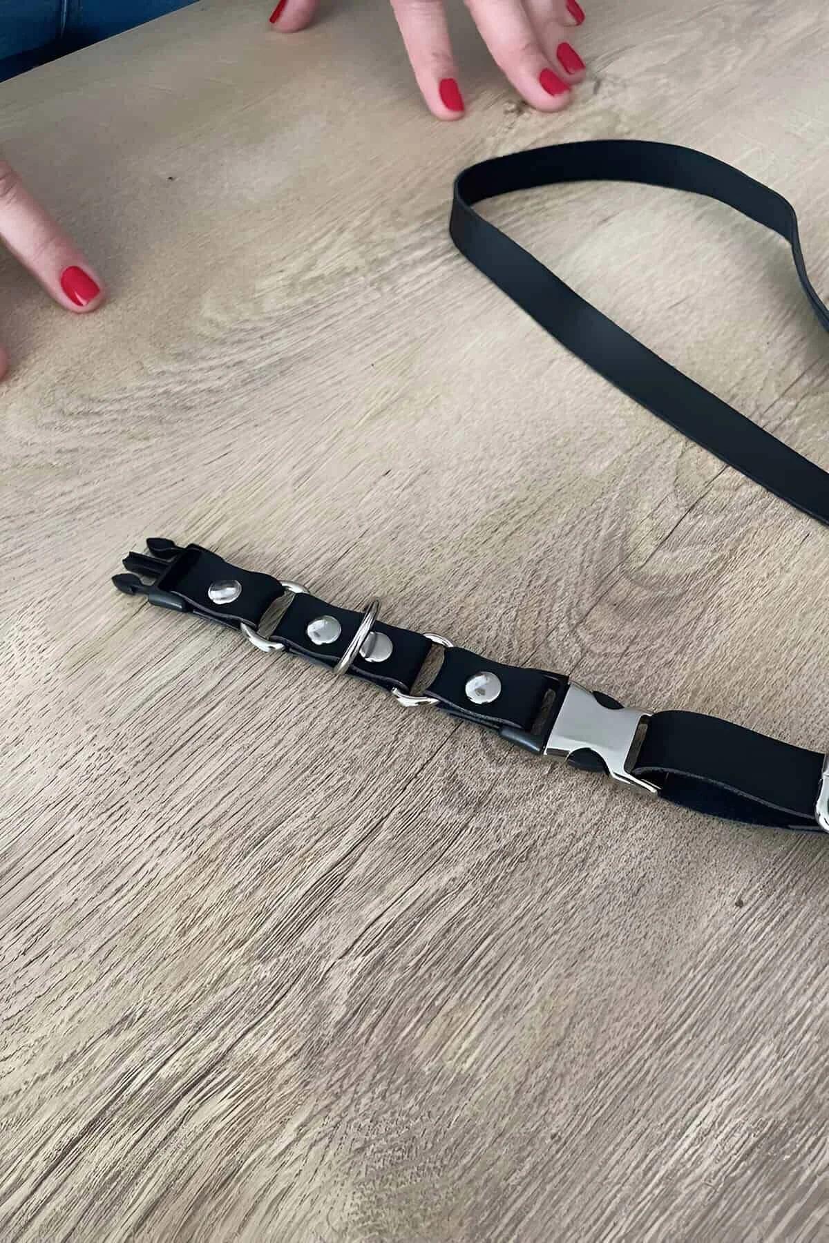 Close-up of silver dome studs and O-ring on black faux leather choker band