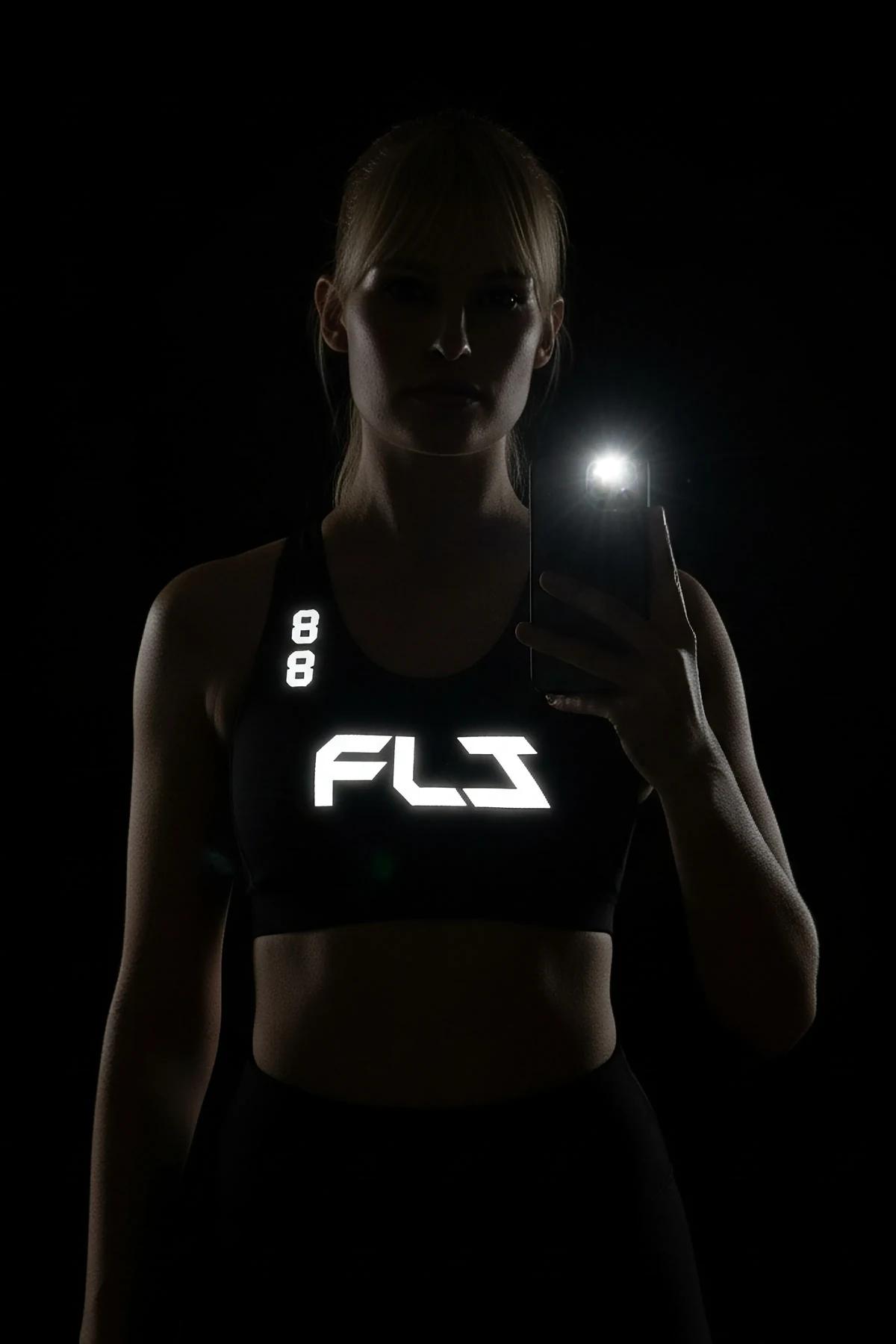 black oversized sport jersey back view with large white reflective number 10 and custom name print