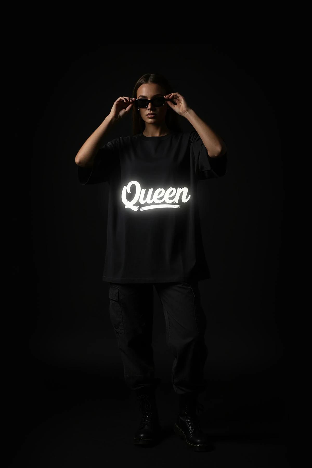 black oversized t-shirt back view with white retroreflective brush-script custom text graphic glowing in low light