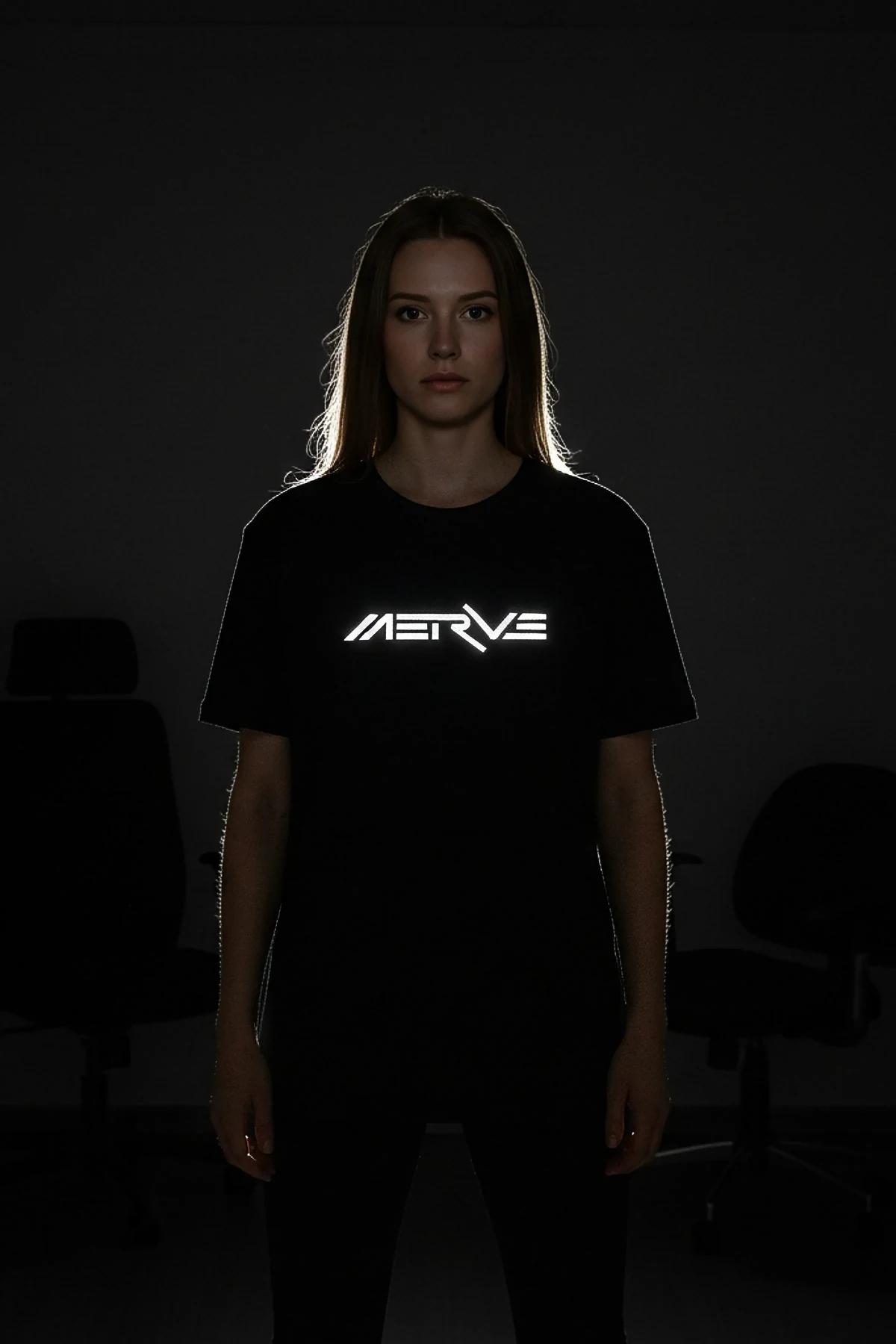 black oversized custom tee with reflective chest print photographed under flash in dark studio