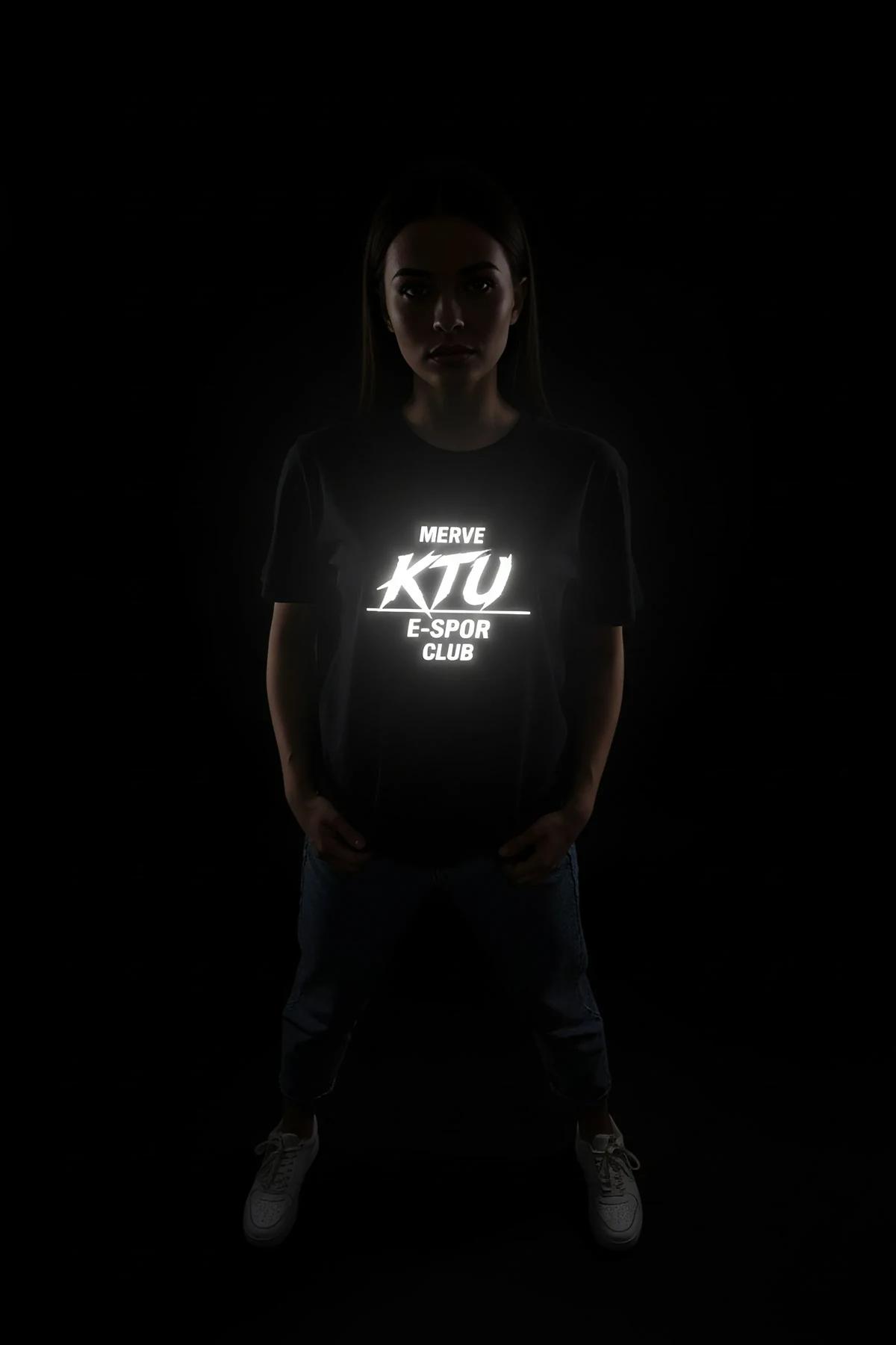 black reflective t-shirt with bright white glowing logo print worn in low-light night setting