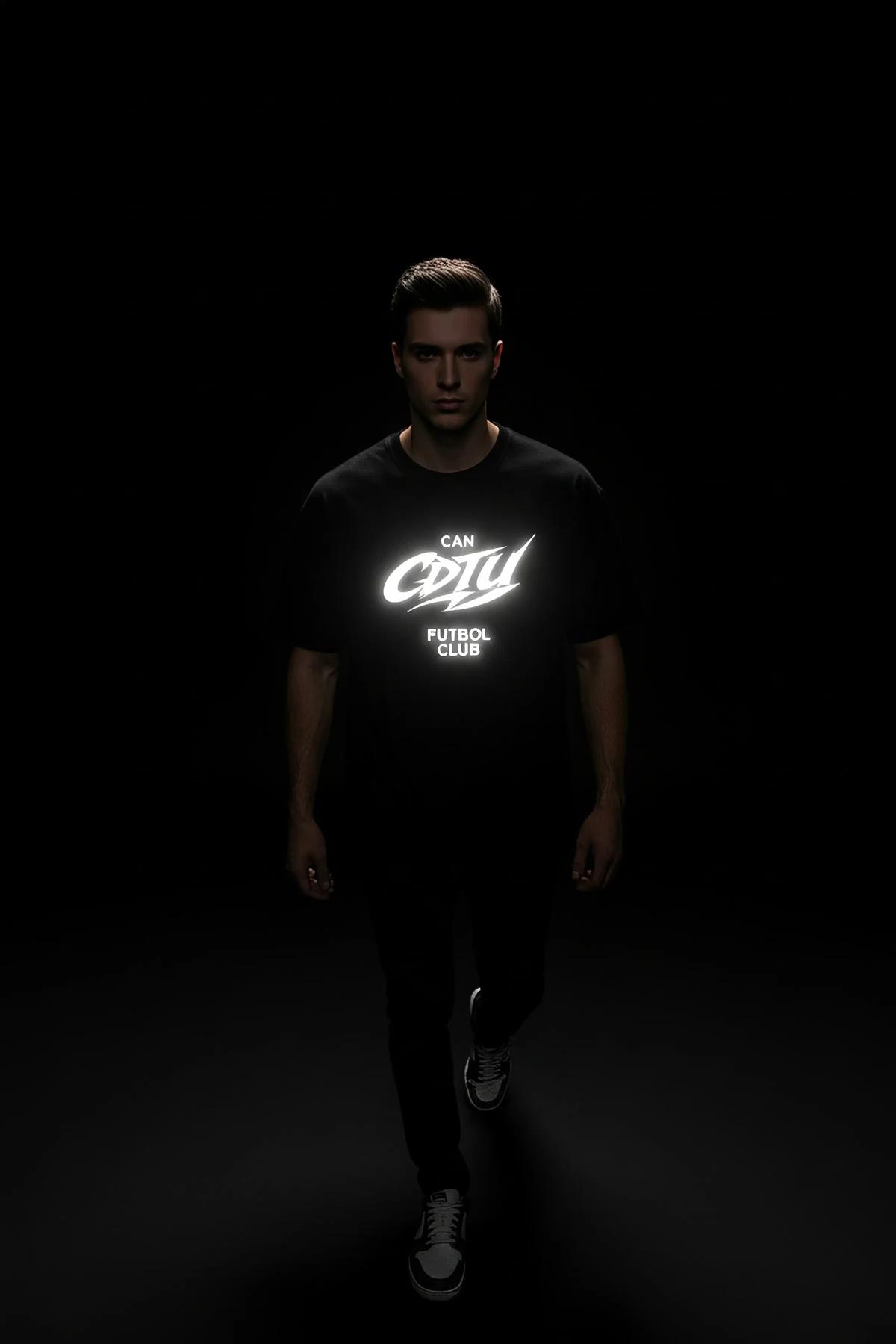 black reflective t-shirt with bright white glowing logo print worn in low-light night setting