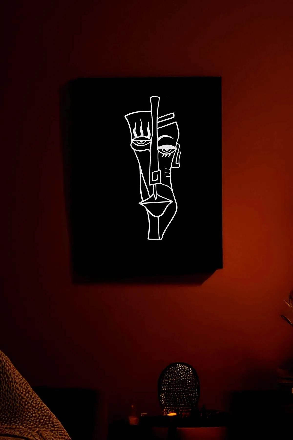 Siyah PU deri kanvas üzerinde reflektörlü beyaz hat çizgisiyle işlenmiş soyut yüz tablosu, loş kırmızı tonlu odada duvarda as