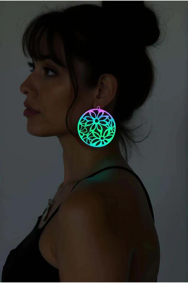Rainbow reflektörlü lazer kesim çiçek motifli büyük daire küpe, pembe yeşil mor holografik yansıma, kulakta gece ışığı efekti