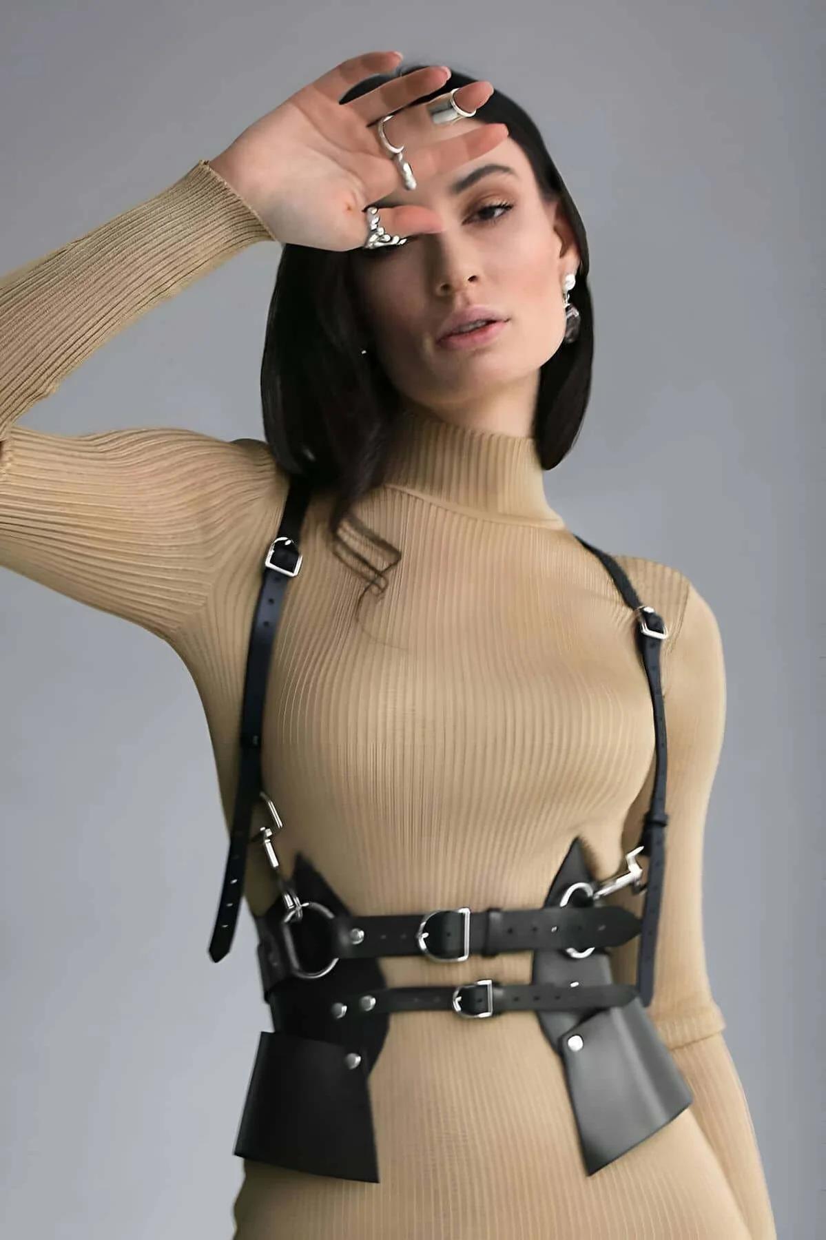 Siyah vegan deri harness kemer gümüş metal tokalar ve göğüs kayışları bej kazak üzerinde
