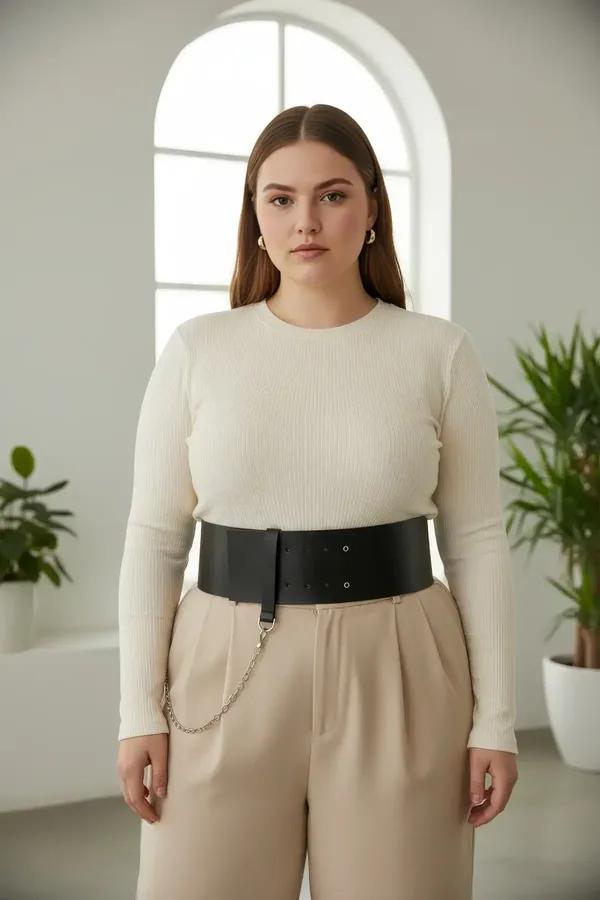 black wide faux leather waist belt with double eyelet rows and silver chain accent worn over white tank top