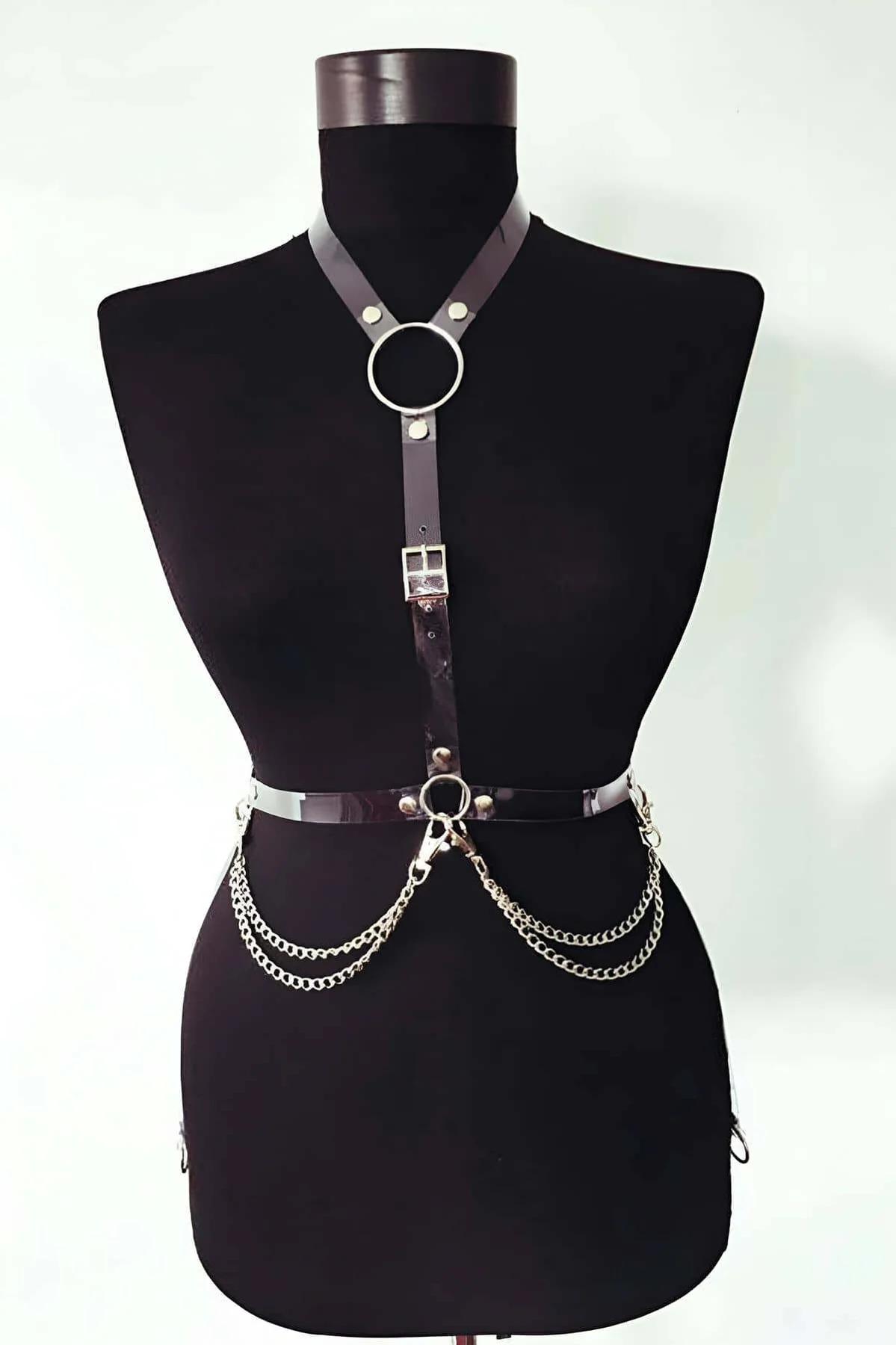black faux leather chest harness with silver O-rings and double drape chain at waist on mannequin
