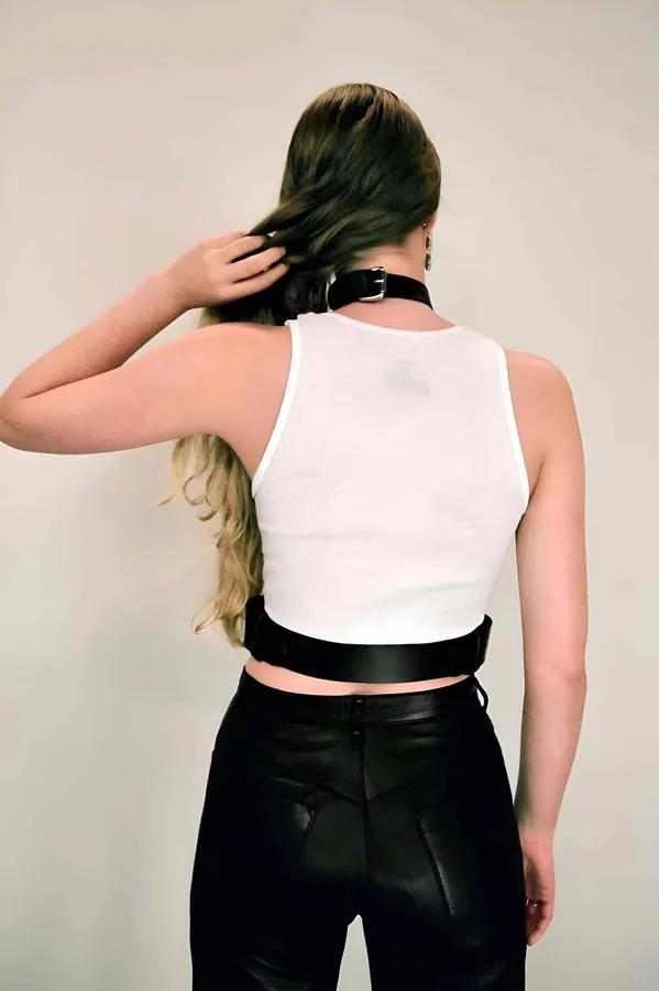 Siyah vegan deri boyun bağlantılı korse harness, gümüş dikdörtgen toka ve D-ring, beyaz atlet üzerinde