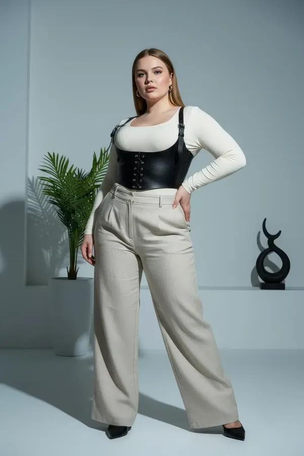 black faux leather underbust corset harness with front lace-up and silver buckle shoulder straps worn over cream top