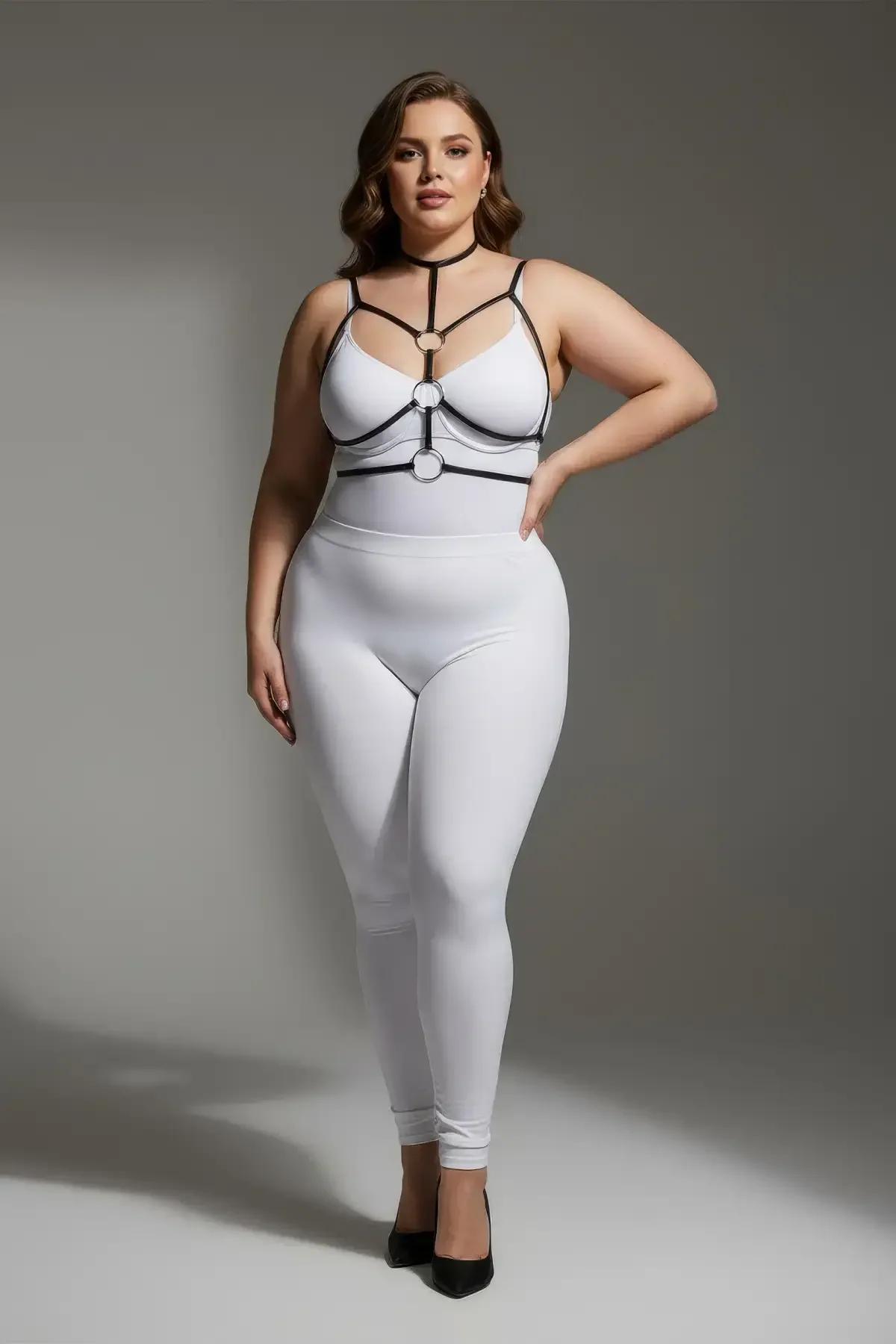 Black faux leather strappy chest harness with double gold O-rings and choker neck strap worn over white outfit