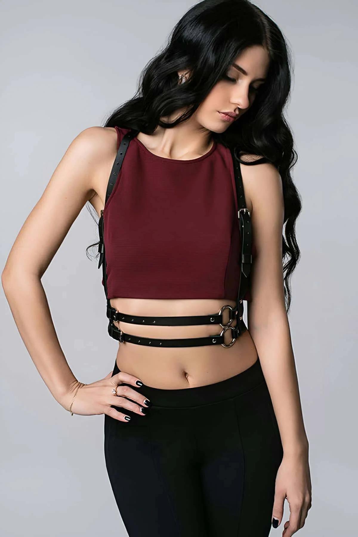 Siyah vegan deri göğüs harness bordo crop top üzerinde, altın O-ring toka ve çift bel bandı detayı