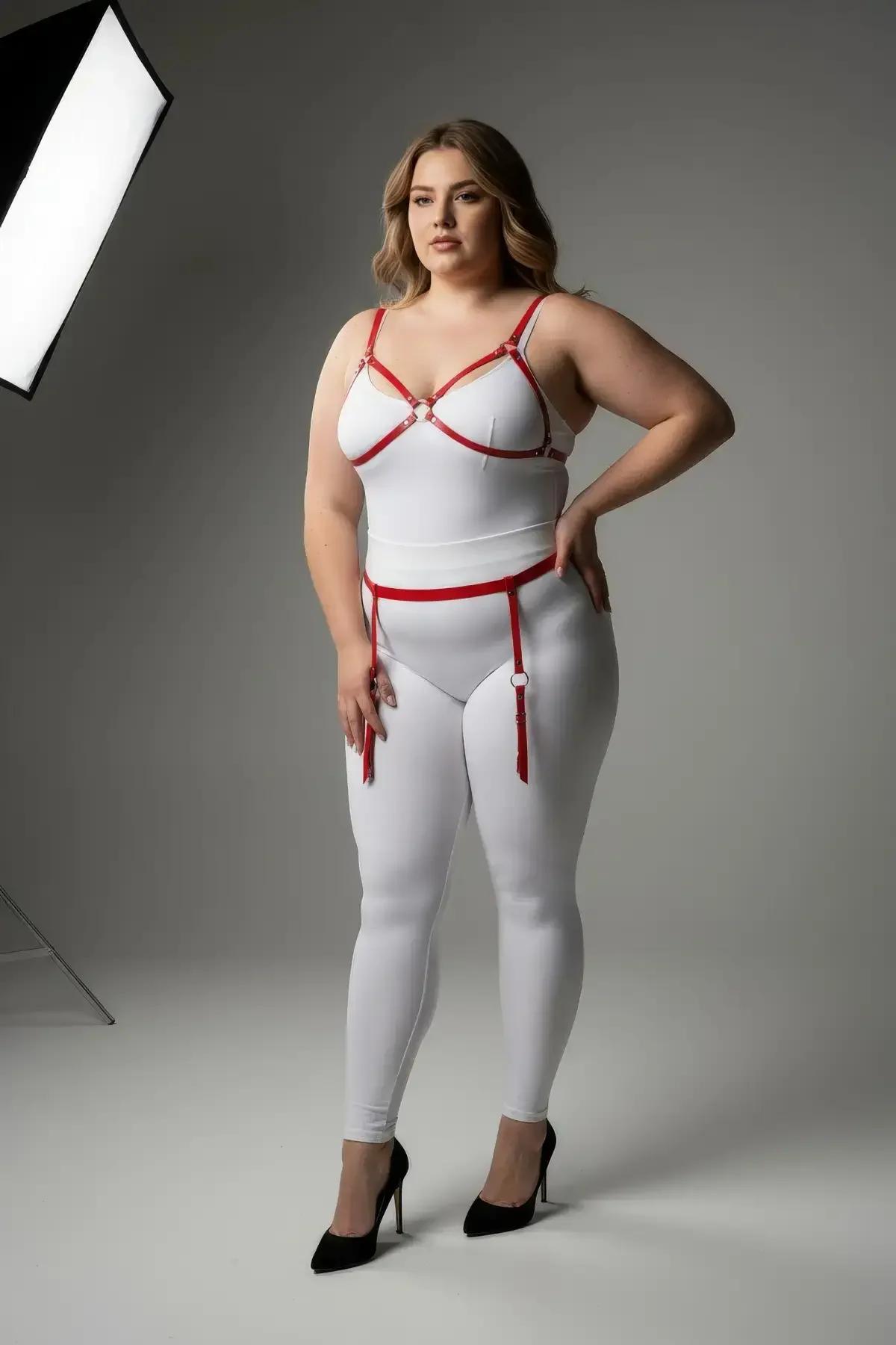 red vegan leather strappy bra harness and thigh garter set with silver O-ring hardware worn over white bodysuit