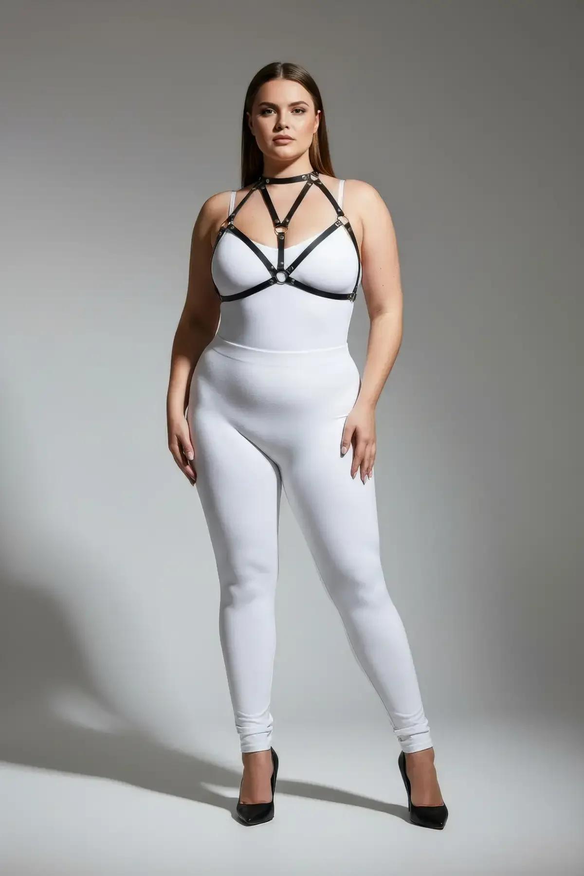 black faux leather strappy body harness with gold O-ring detail and choker collar worn over white bodysuit