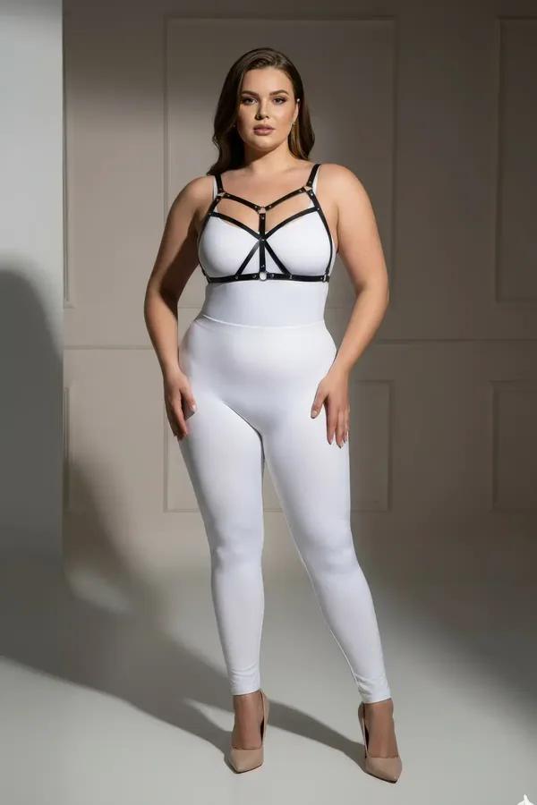 Strappy black faux leather body harness with gold O-ring hardware worn over white bodysuit, cage-style chest strap design