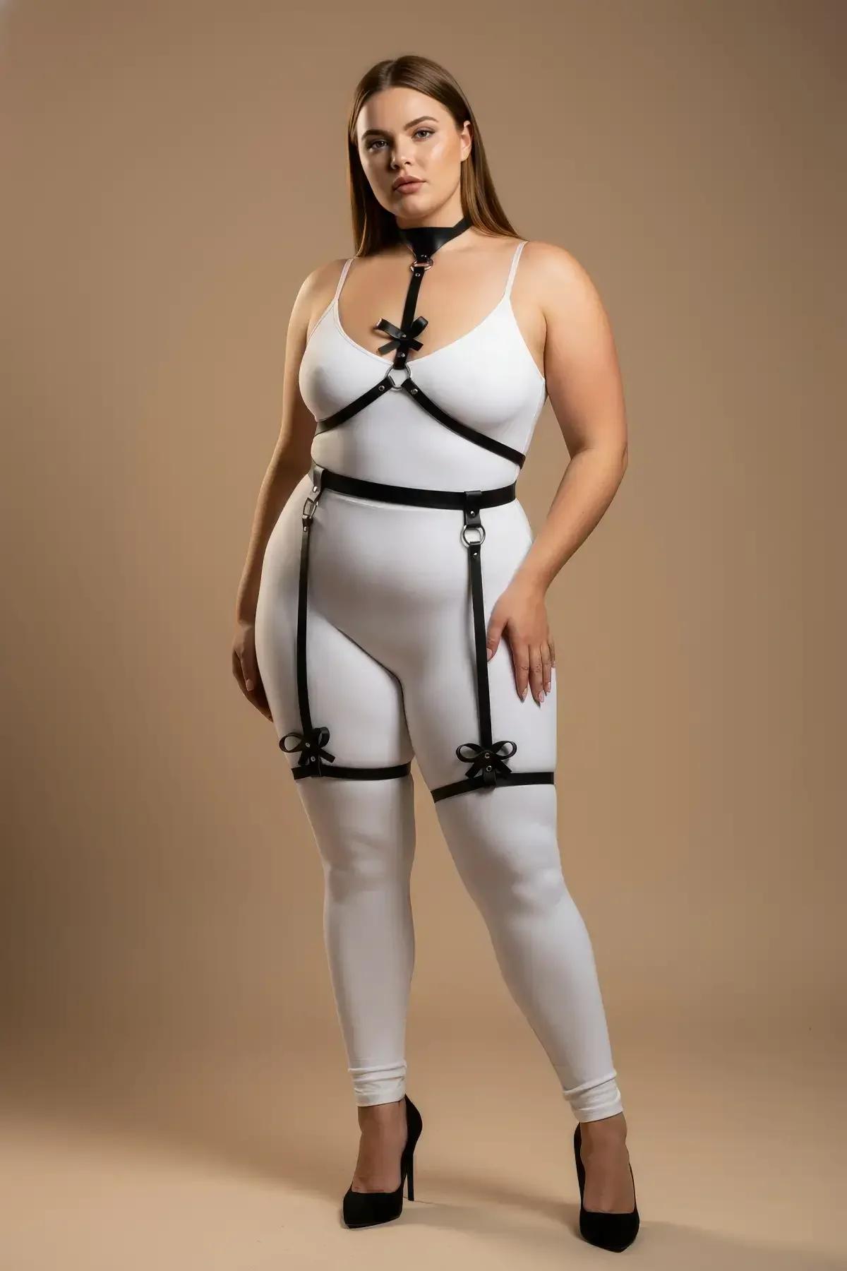 black faux leather body harness with bow garter straps and silver O-ring waist belt, worn on plus-size model