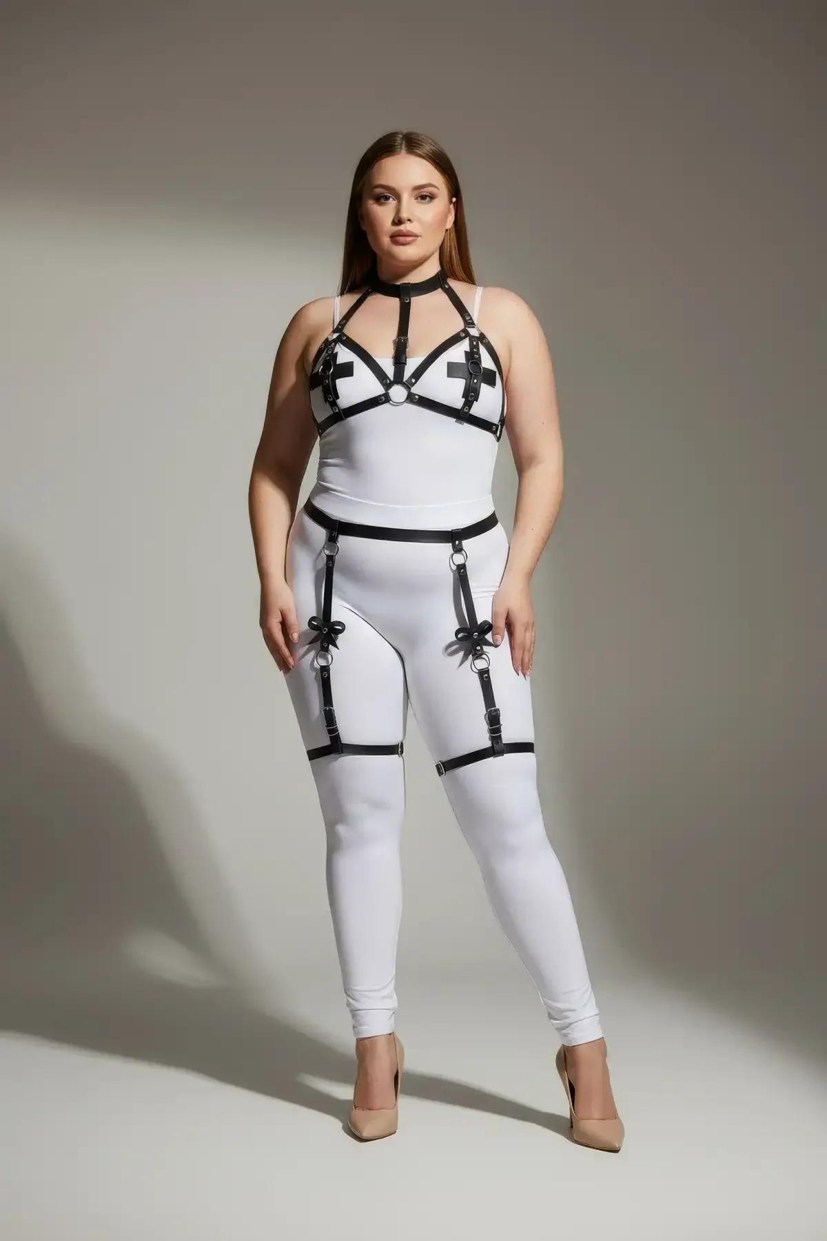 black vegan leather strappy garter body harness with silver O-rings and cross accents worn over white bodysuit