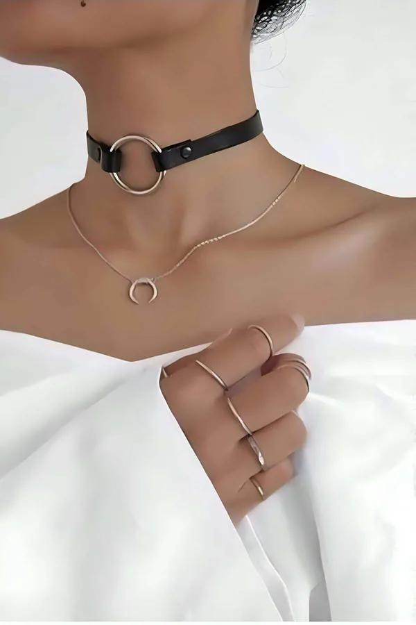 Siyah suni deri choker gold O-halka detaylıyla model boynunda, beyaz kıyafet üzerinde