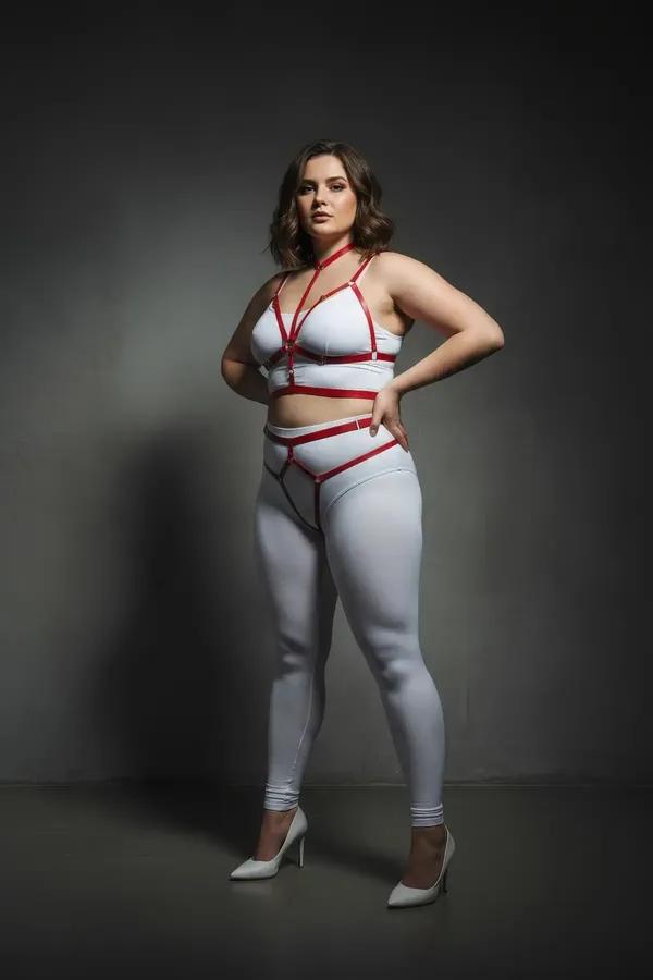 red faux leather full body cage harness with thigh straps and gold O-ring hardware on plus-size model
