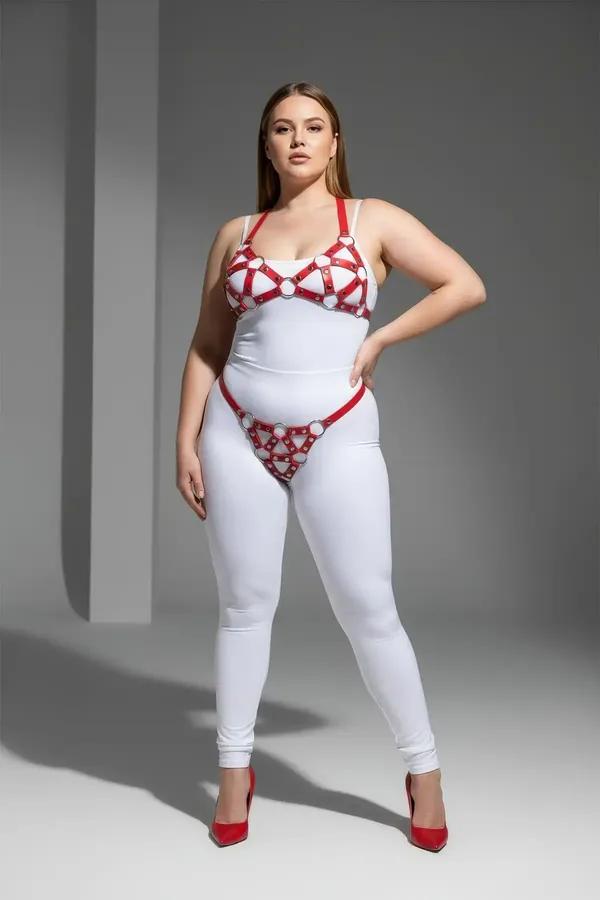 red faux leather cage bra and panty harness set with chrome O-rings and geometric strap pattern on plus-size model