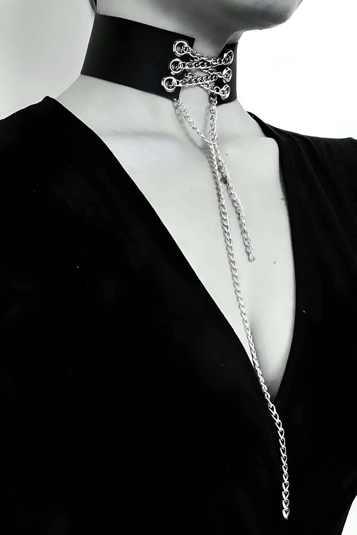 black faux leather choker with 4 silver O-rings and 3 cascading silver chains on black dress neckline