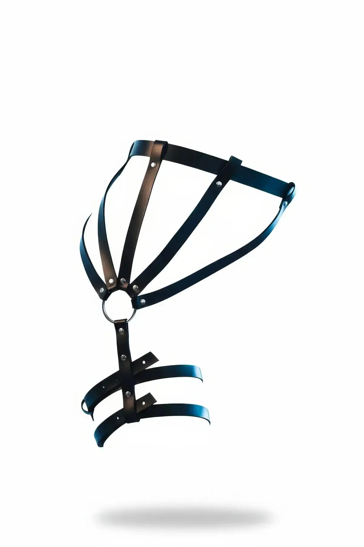 Black faux leather thigh garter harness with silver O-ring center and five-strap cage upper panel over bare white background