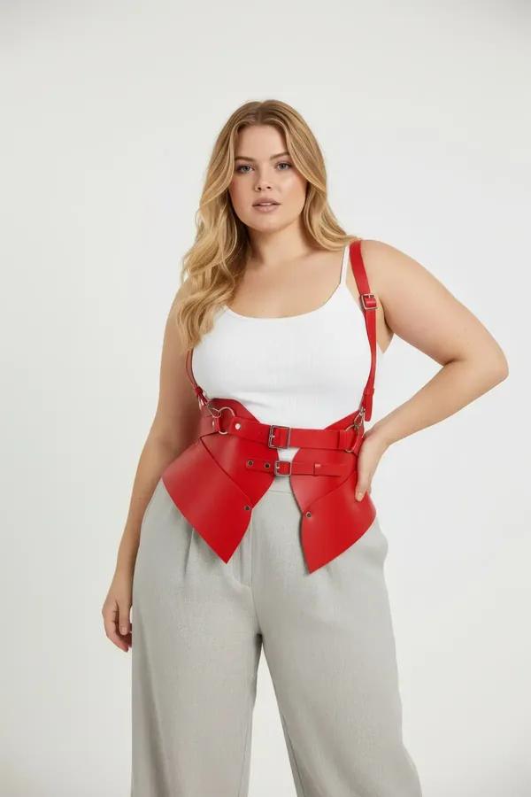 Red faux leather waspie corset harness with gold buckles and adjustable shoulder straps worn over cream bodysuit