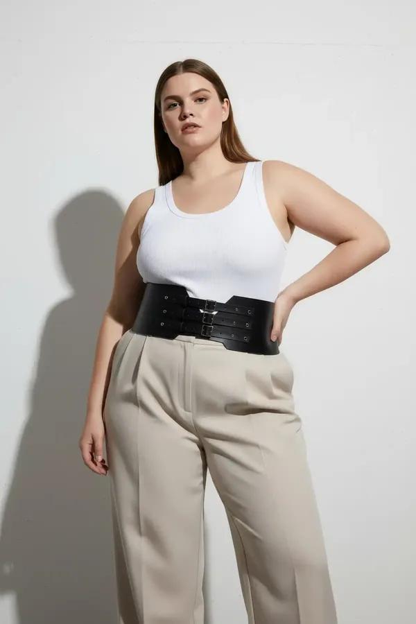 black faux leather wide waist harness belt with three silver buckles and stud detail worn over white tank top