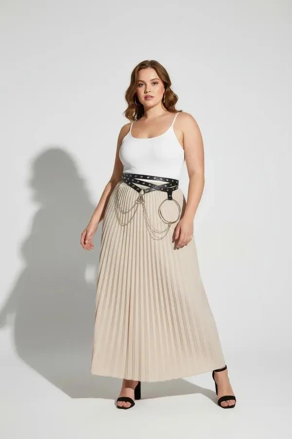 black faux leather waist harness with silver grommets, large O-ring and draped chain detail worn over wide-leg trousers