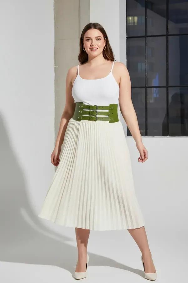 olive green faux leather wide waspie belt with three silver prong buckles worn over white bodysuit and cream trousers