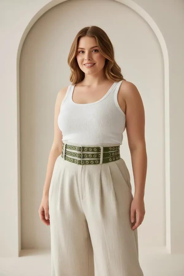 Khaki faux leather triple-row grommet waist harness belt with silver eyelets worn over cream linen dress