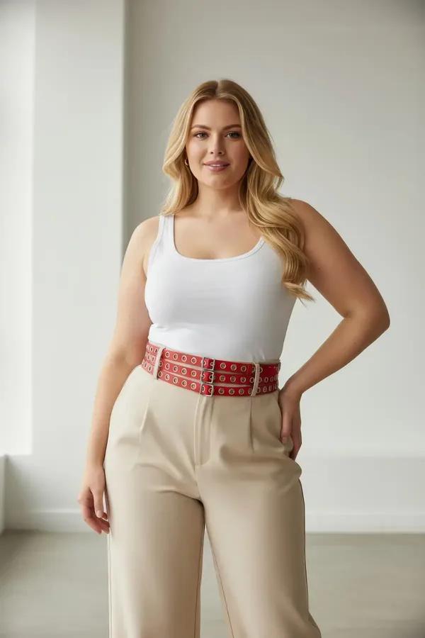 red triple-row faux leather waist harness belt with silver eyelet grid and square buckle closure worn over cream tank top