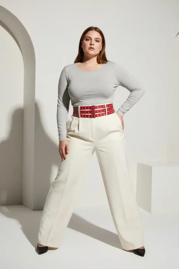 red triple-row faux leather waist harness belt with silver eyelet grid and square buckle closure worn over cream tank top