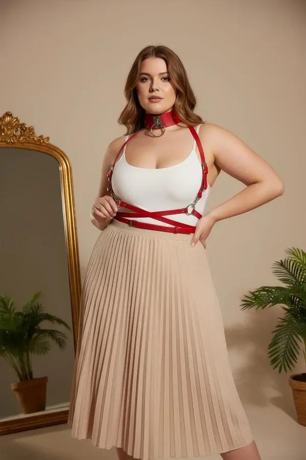 red faux leather harness bra with silver O-ring choker and waist belt worn over cream tank top, plus-size model