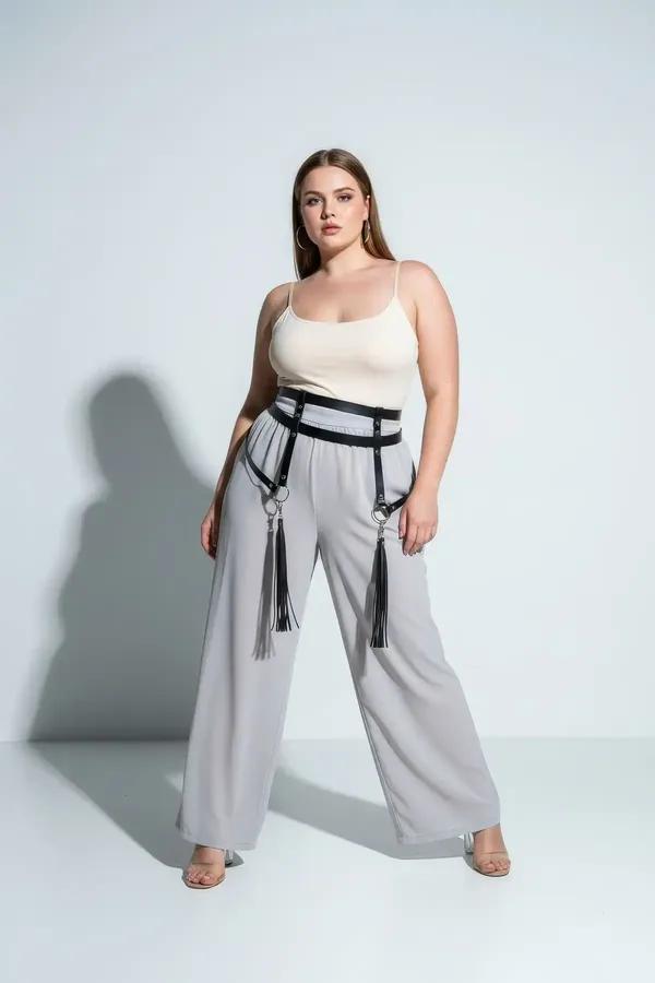 black faux leather waist harness with detachable tassel garters and silver stud hardware worn over jeans