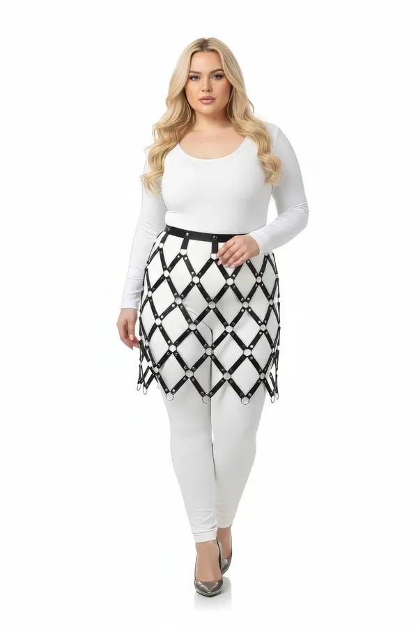 black faux leather diamond lattice skirt overlay harness with silver O-rings worn over white bodysuit and leggings