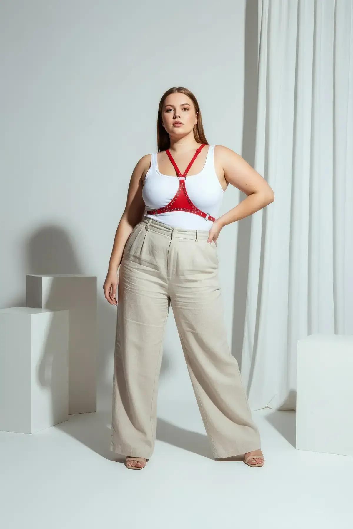 red faux leather minimalist chest harness with silver studs worn over white tank top plus size model