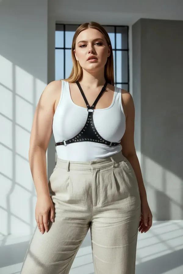 black faux leather chest harness with silver stud band and central O-ring worn over white tank top