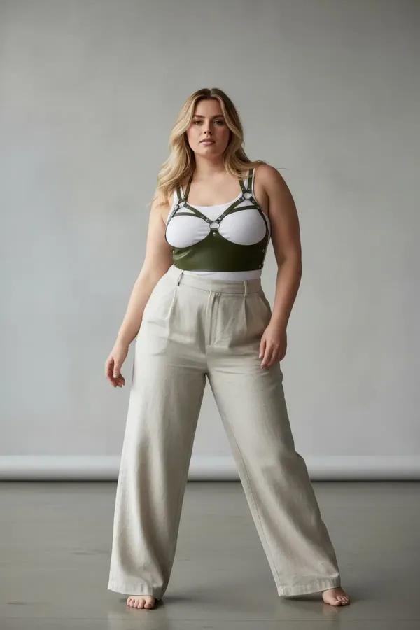 dark olive caged underbust faux leather harness with silver rivet details and O-ring chest panel worn over cream tank top