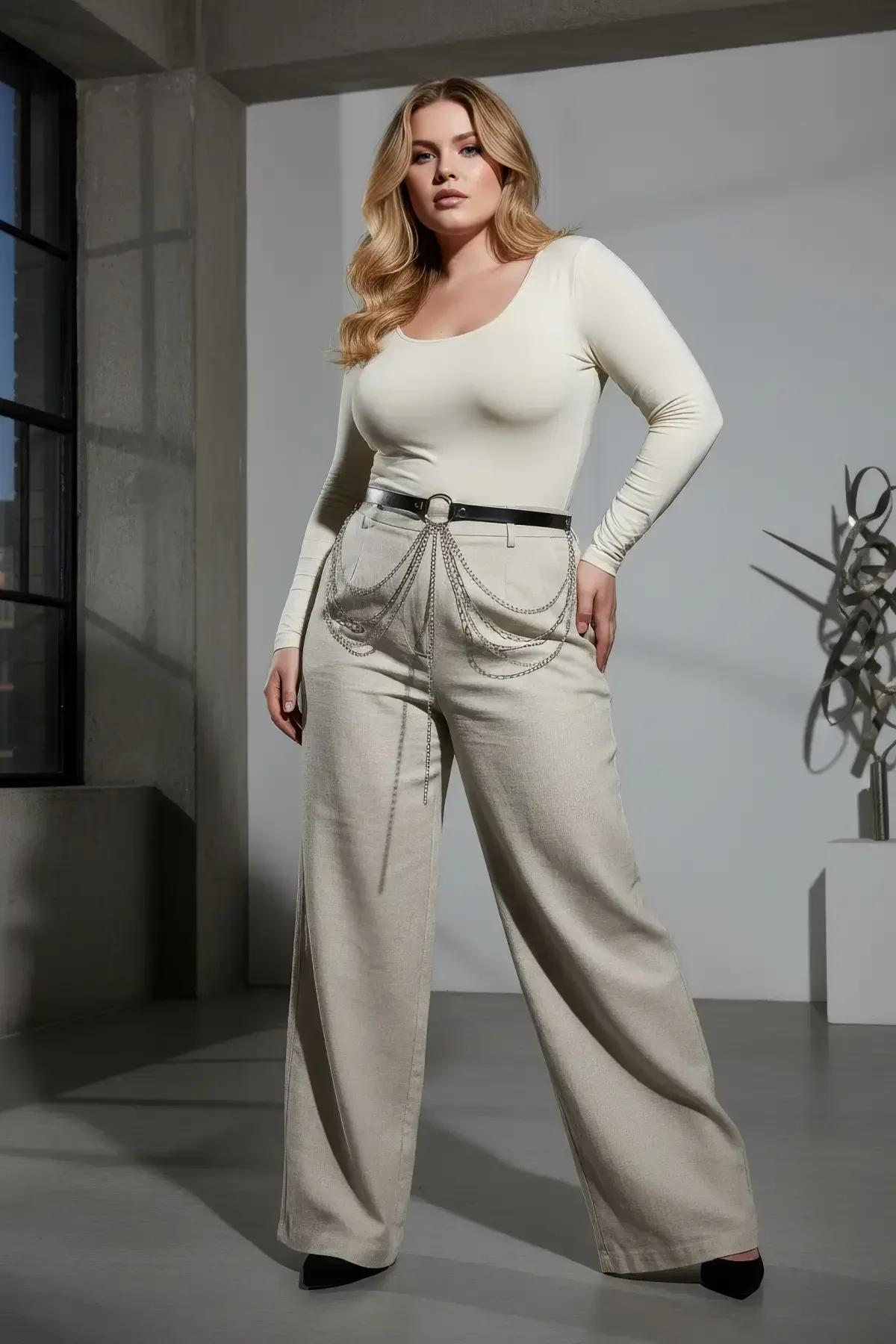 black faux leather O-ring belt with cascading silver chains worn over wide-leg trousers as a waist harness