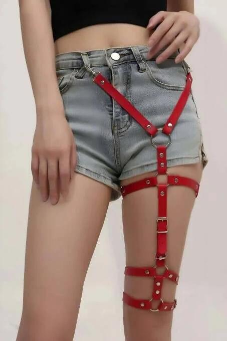 Kırmızı vegan deri tek bacak jartiyer harness gümüş O-ring ve çift metal toka detayı denim şort üzerinde