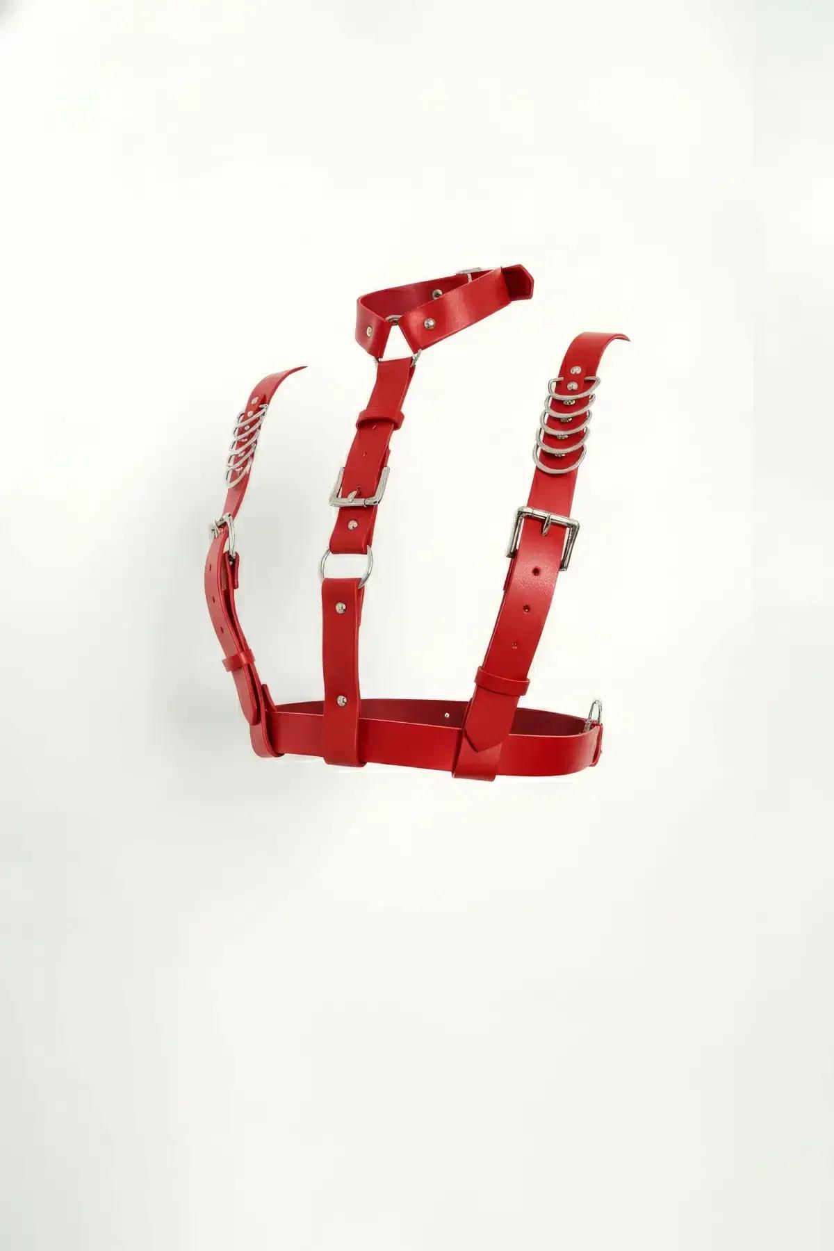 Red faux leather chest harness with silver chain O-rings and pin-buckle closures, structured cage silhouette on white backgro