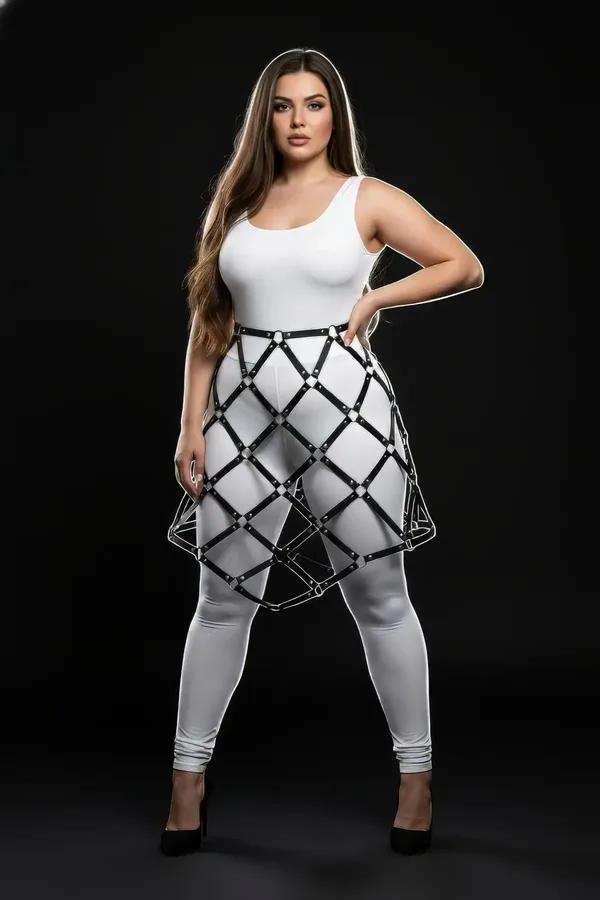 black faux leather geometric cage skirt harness with silver rivet detailing worn over white leggings