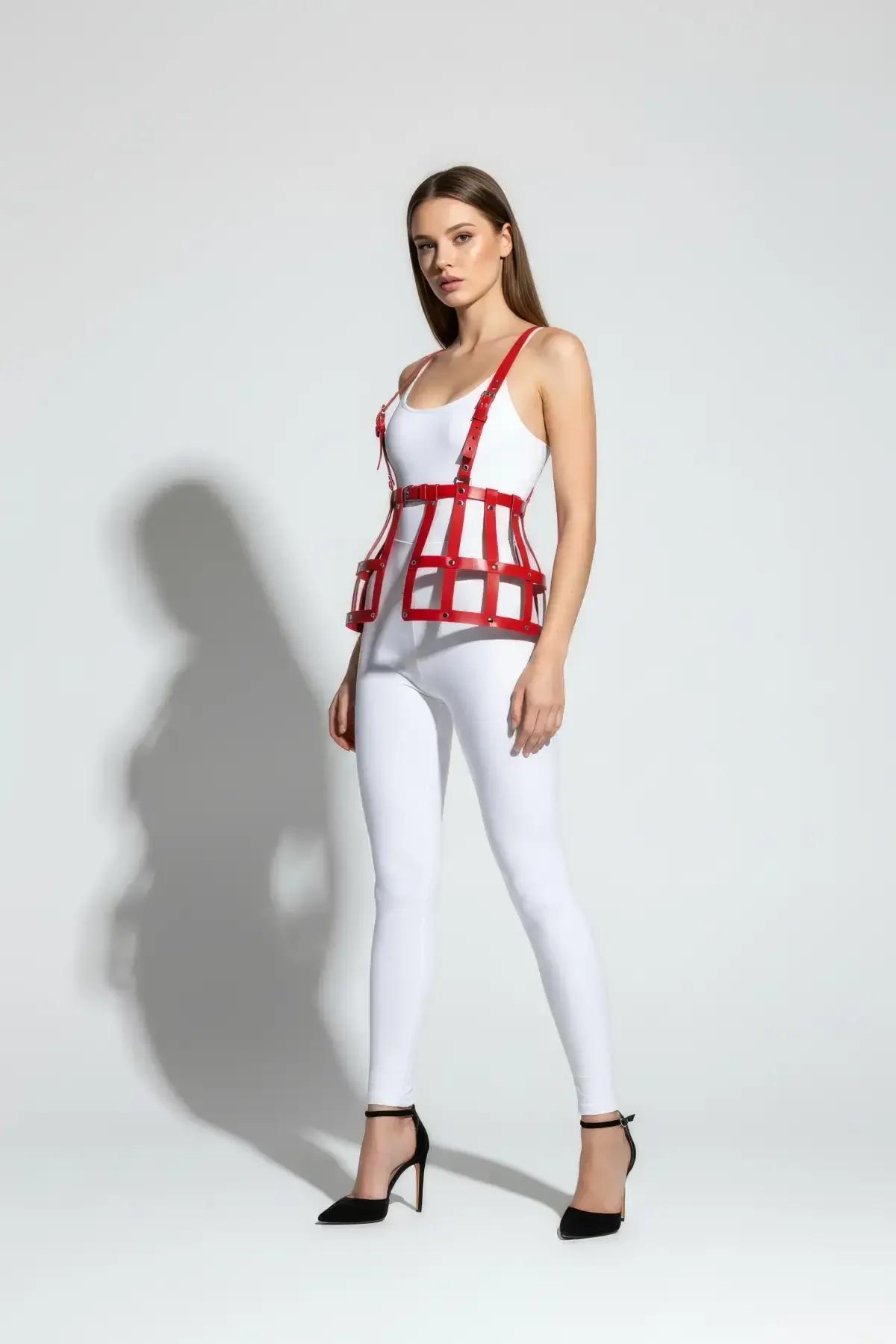 red faux leather cage waist harness with silver rivets and adjustable shoulder straps worn over white bodysuit