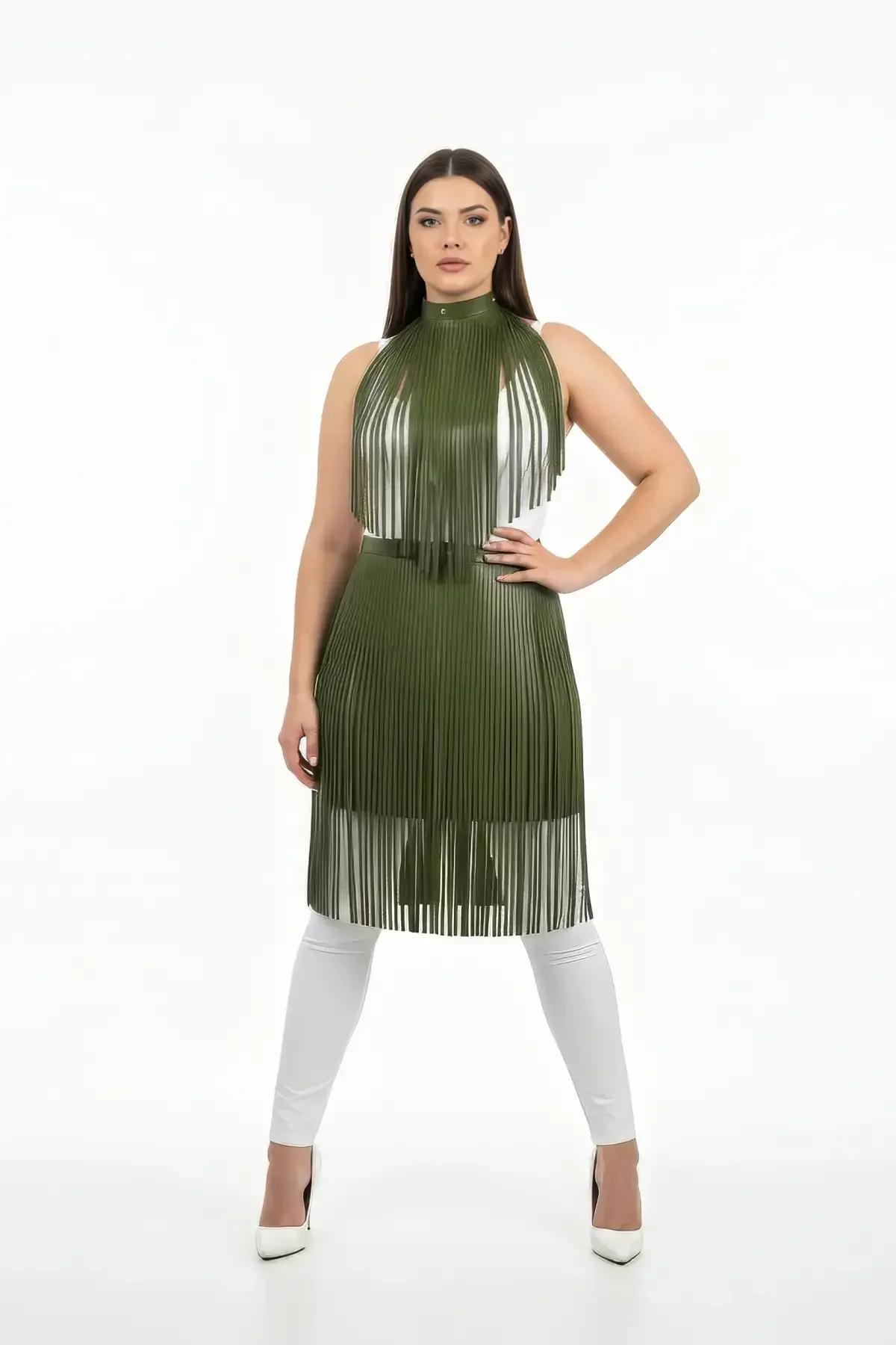 Olive green vegan leather fringed halterneck top with belted waist, full-length fringe strips falling to knee, styled over wh