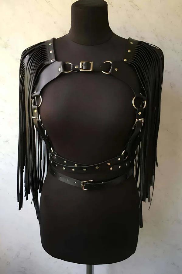 Püsküllü siyah vegan deri ceket harness manken üzerinde, gümüş toka ve O-halka detaylı omuz püskül kanatları